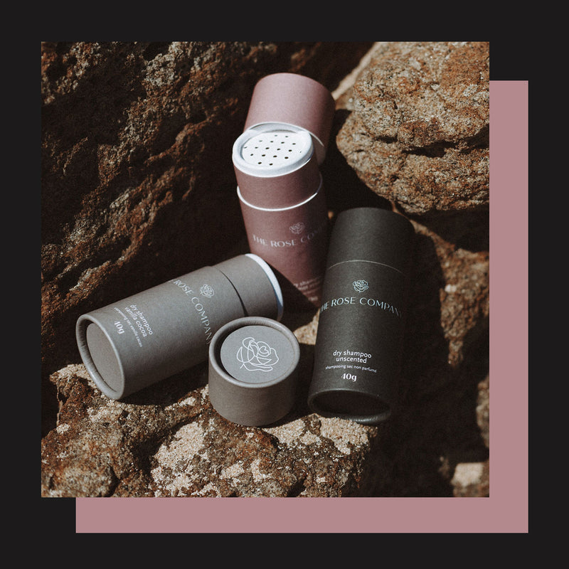 The Rose Company Vegan Dry Shampoo in three scents: Rosemary Bergamot, Vanilla Cocoa, Unscented in compostable sustainable paper tube packaging.